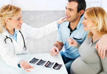 Young family visiting a doctor, looking at Ultrasound.